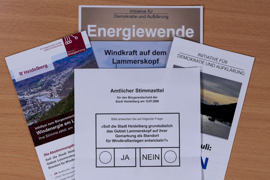 Amtlicher Stimmzettel und Flyer zu Windkraft und Energiewende auf Holzuntergrund.
