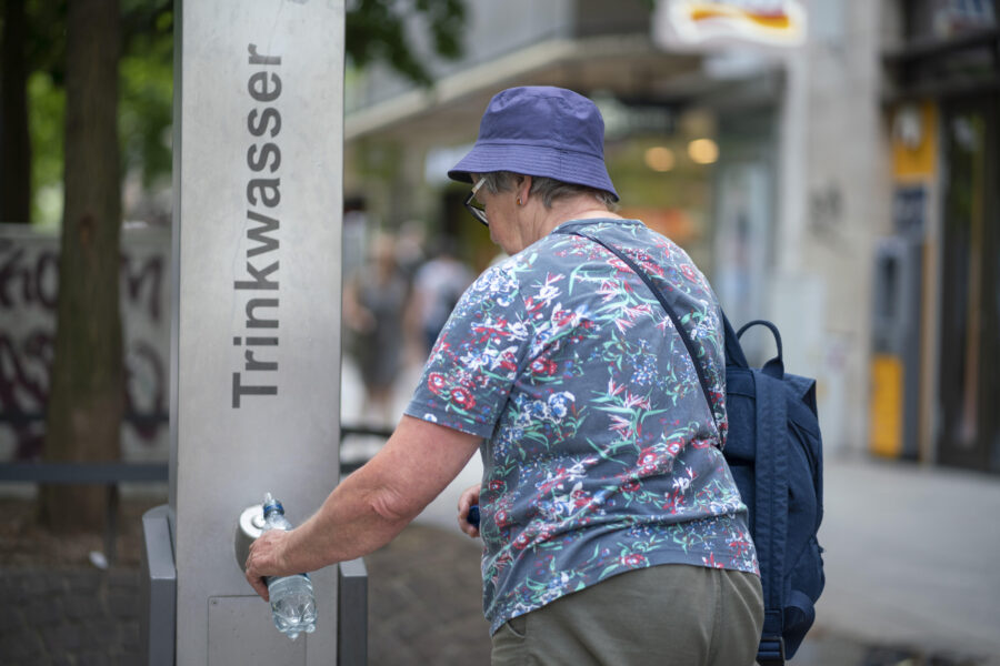 Person füllt Flasche an Trinkwasserstation.