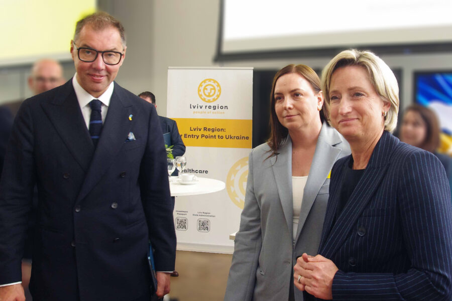 Drei Personen stehen vor einem Banner mit der Aufschrift "Lviv Region".