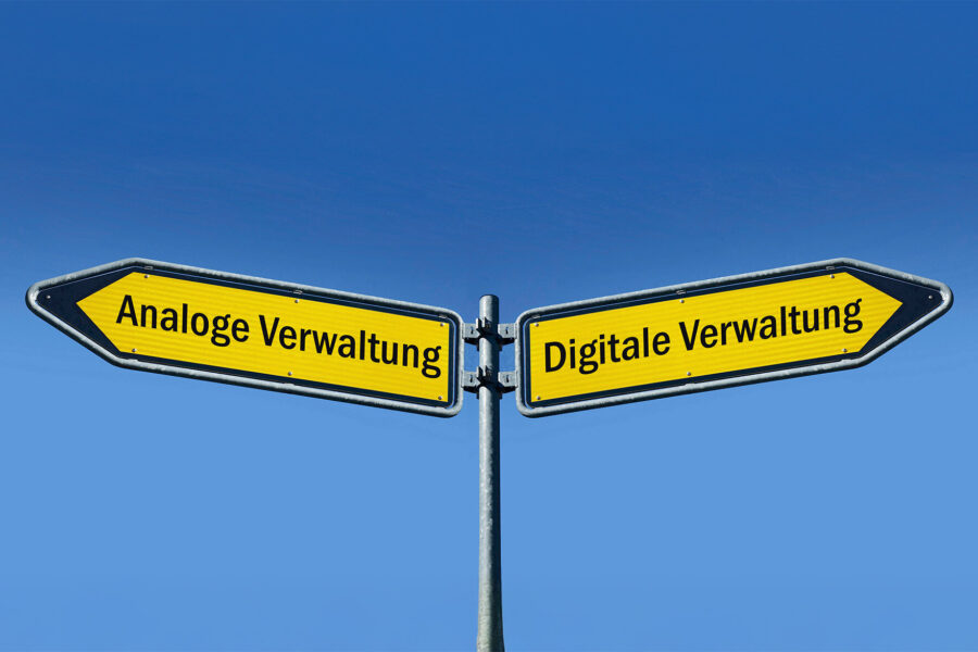 Zwei gelbe Wegweiser: "Analoge Verwaltung" links, "Digitale Verwaltung" rechts.
