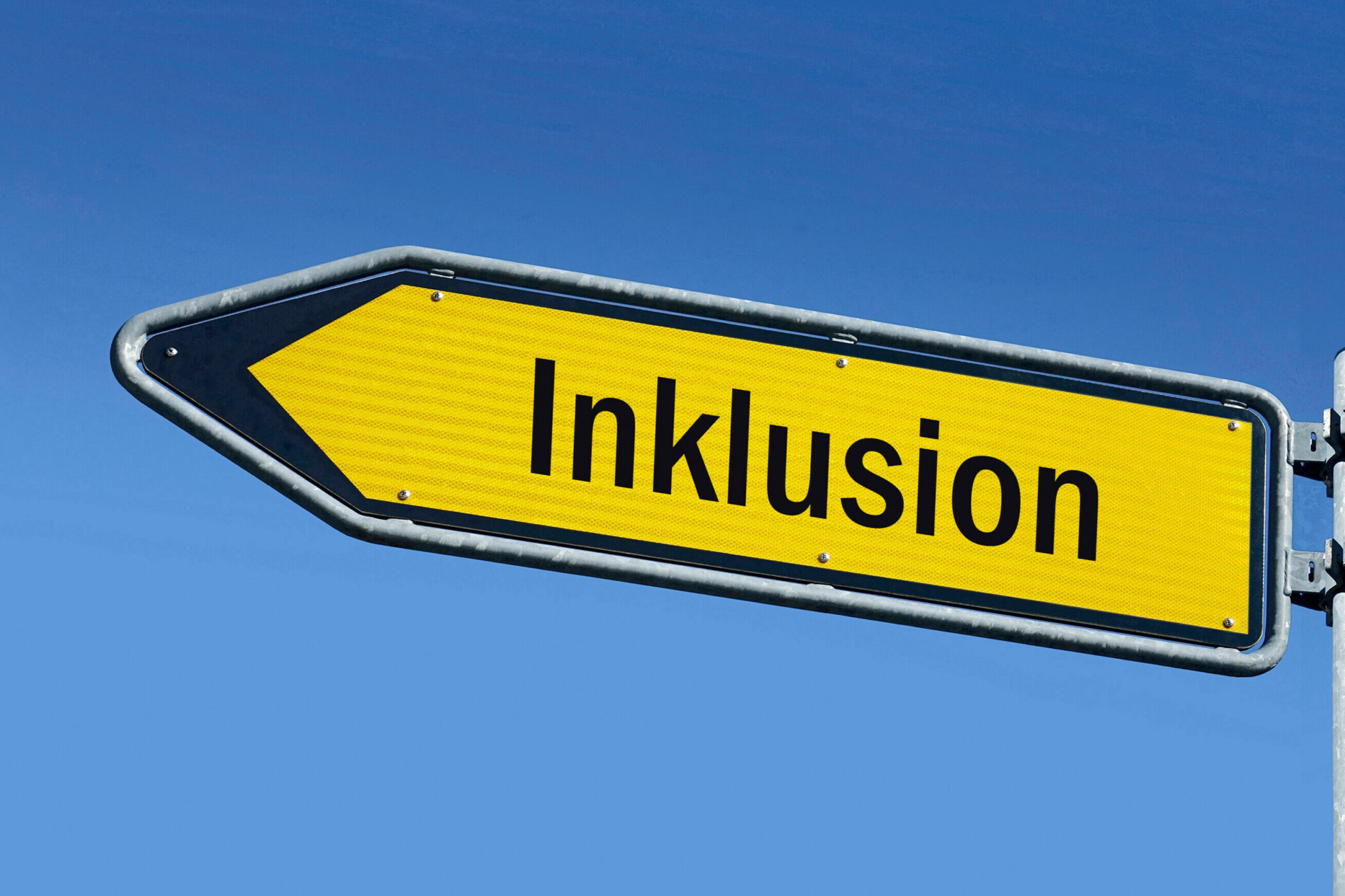 Gelbes Schild mit Pfeil und dem Wort „Inklusion“.