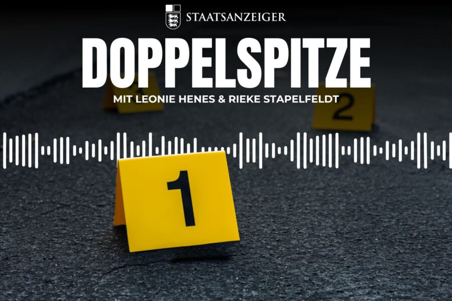 Gelbe Marker mit Zahlen 1 und 2 auf Asphalt, Text: DOPPELSPITZE.