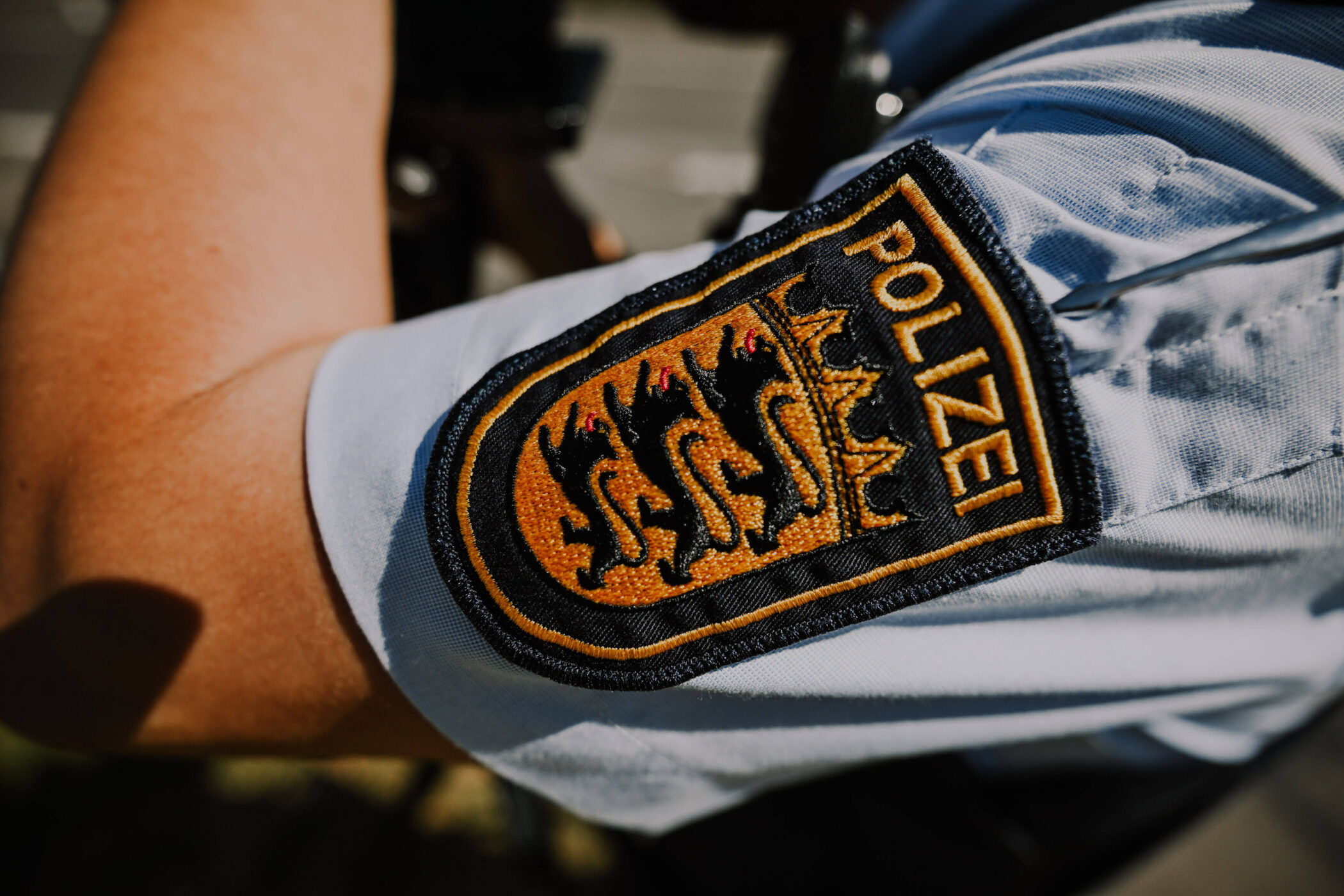 Nahaufnahme eines Polizeiabzeichens auf einem Ärmel.