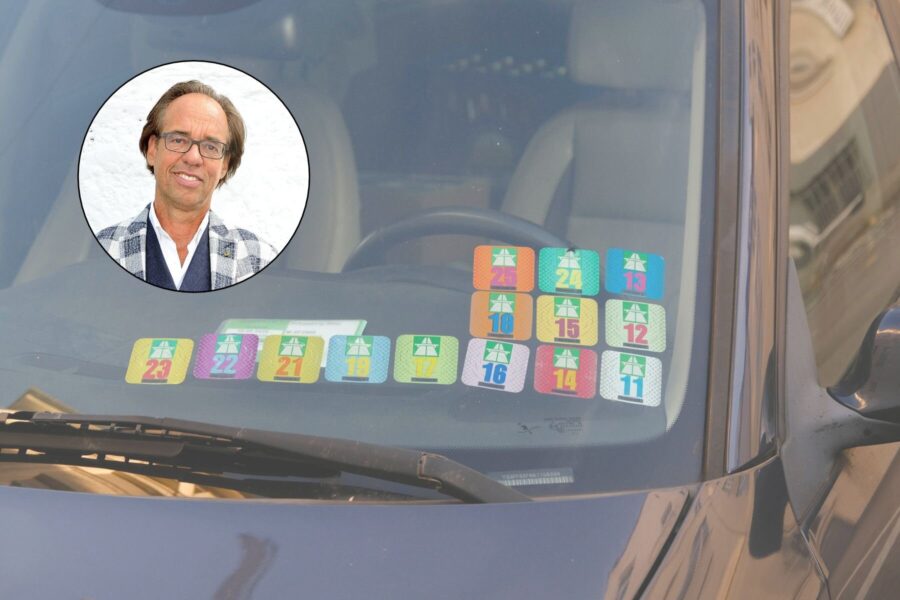 Auto-Windschutzscheibe mit bunten Vignetten, rundes Porträt eines Mannes oben links.