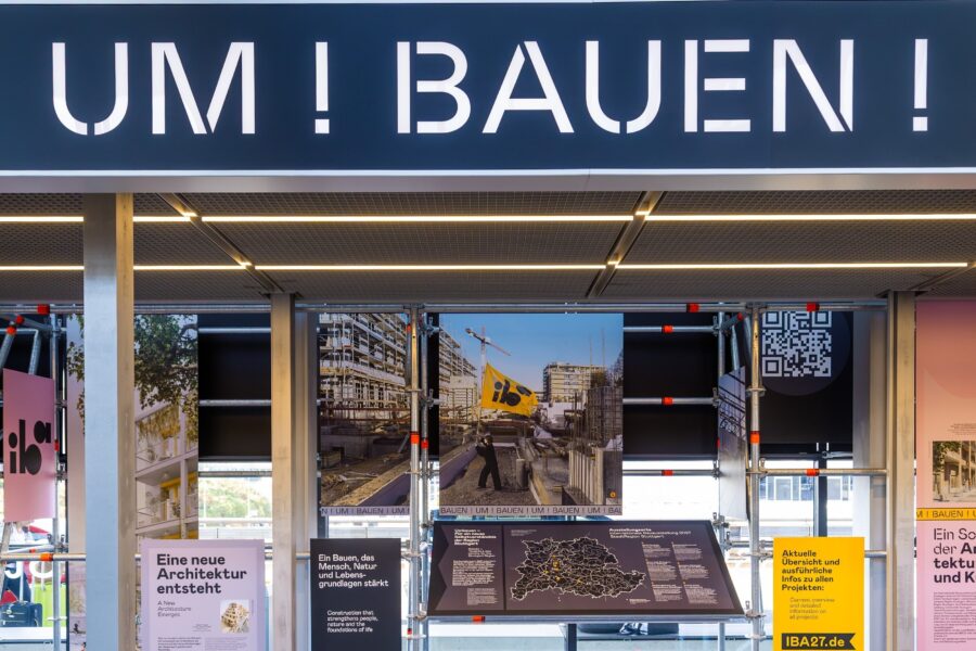 Schriftzug "UM!BAUEN!", Informationstafeln und QR-Code in einer Ausstellung.