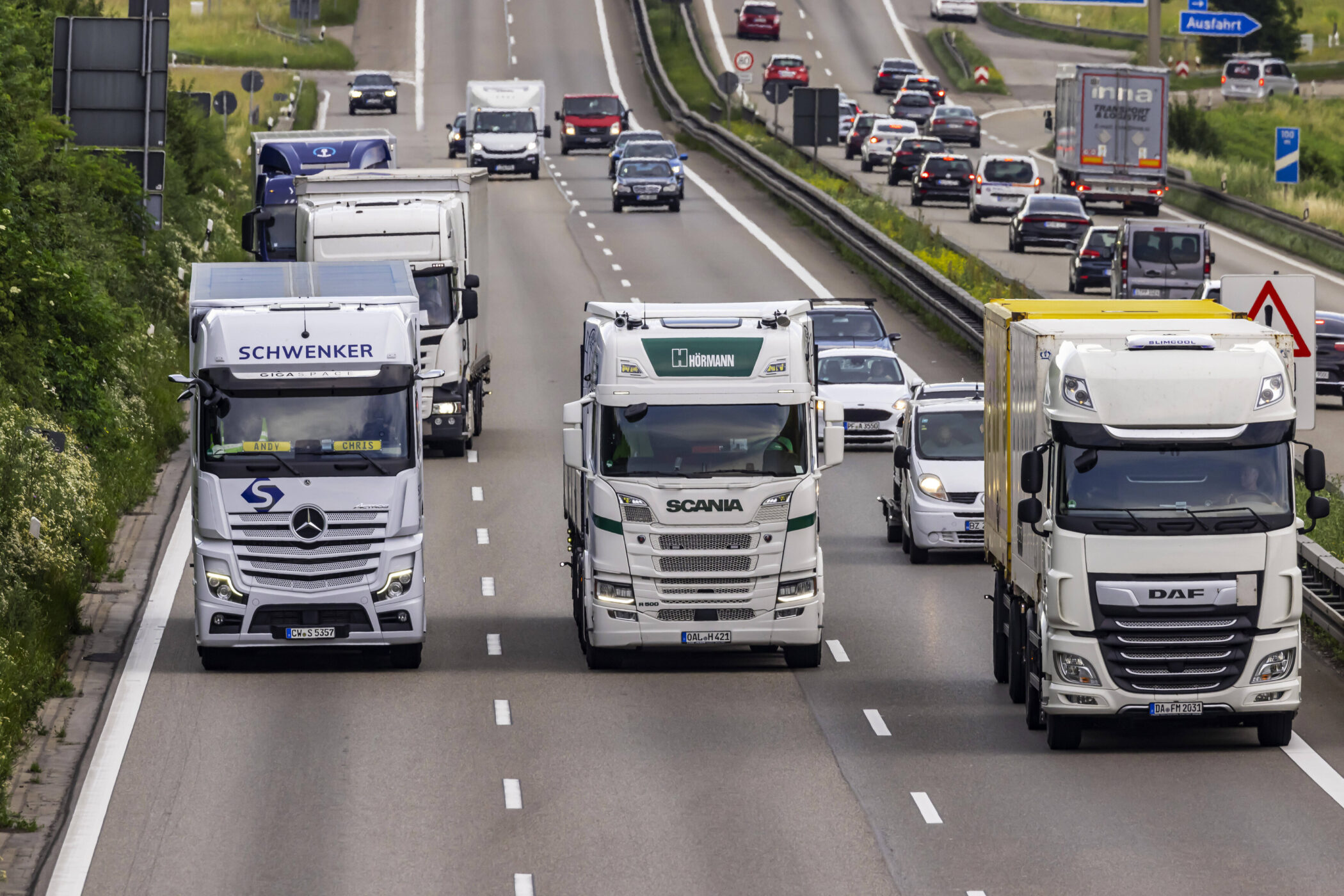 Mehrere Lkw und Autos auf einer Autobahn, teils dichter Verkehr.