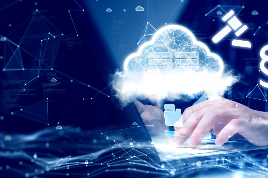 Hände tippen auf Laptop, Wolke und Symbole im Hintergrund.