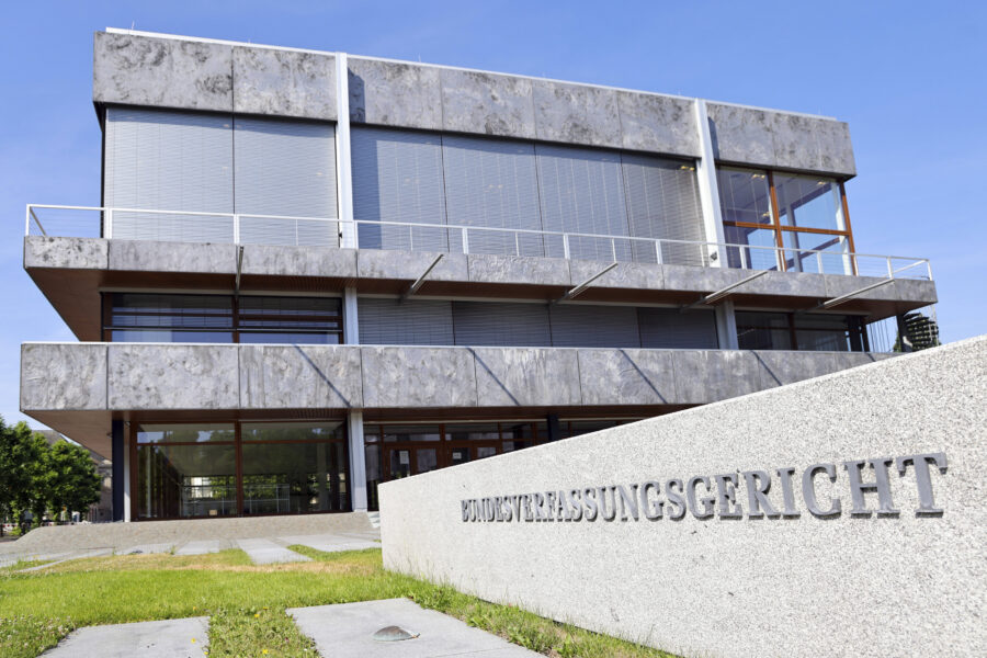 Gebäude mit grauer Fassade, Schriftzug "BUNDESVERFASSUNGSGERICHT" auf Mauer.
