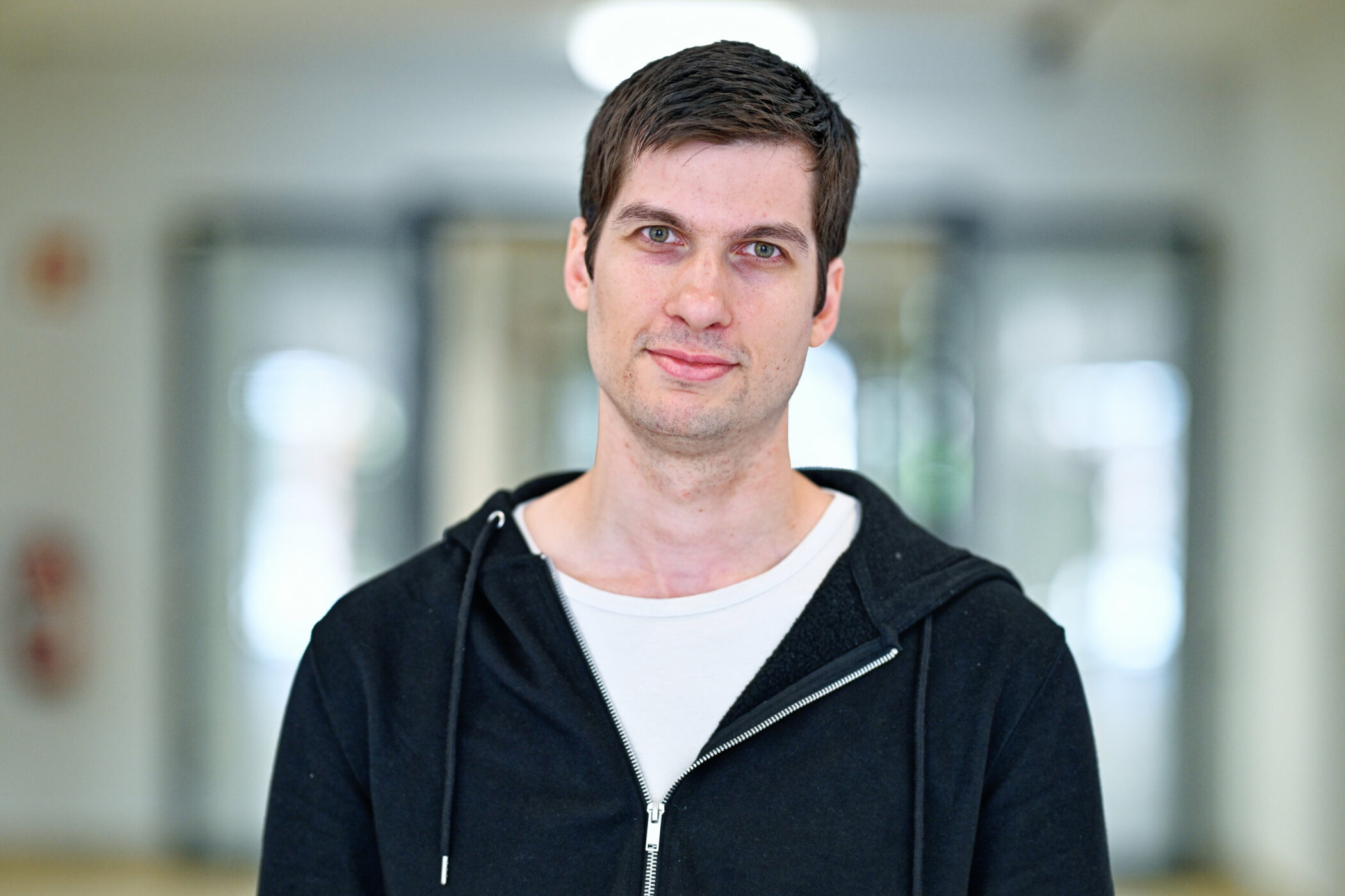 Eine Person in schwarzem Hoodie in unscharfem Hintergrund.