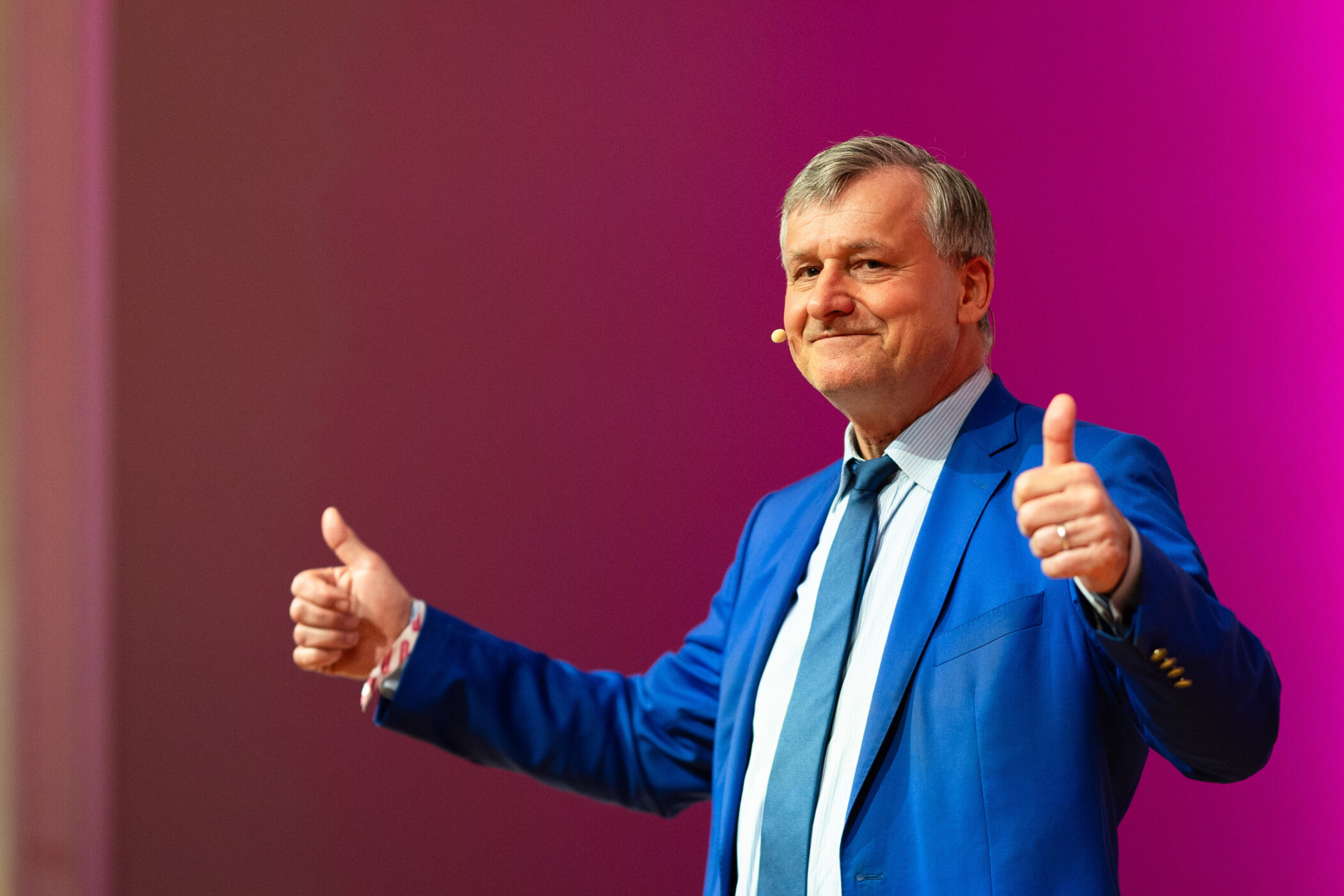 Mann in blauem Anzug zeigt beide Daumen hoch.