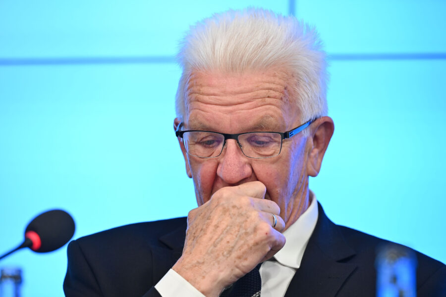 Älterer Mann mit Brille, nachdenklich, Hand vor dem Mund.