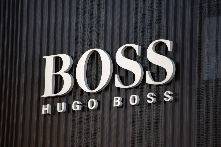 Weiße Buchstaben "BOSS HUGO BOSS" auf geriffeltem, dunklem Hintergrund.