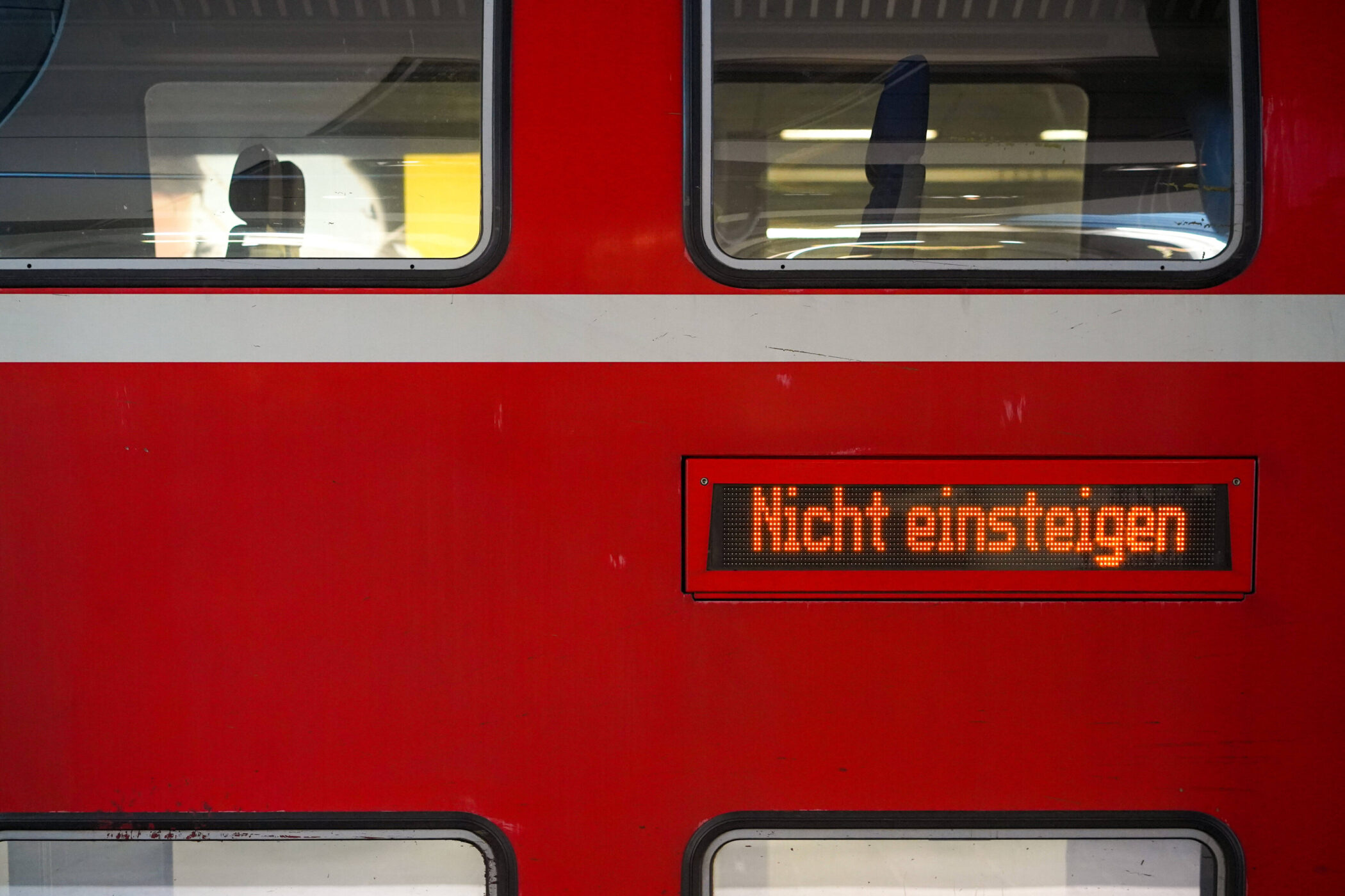Rotes Zugabteil mit Schriftzug „Nicht einsteigen“ auf Anzeigetafel.