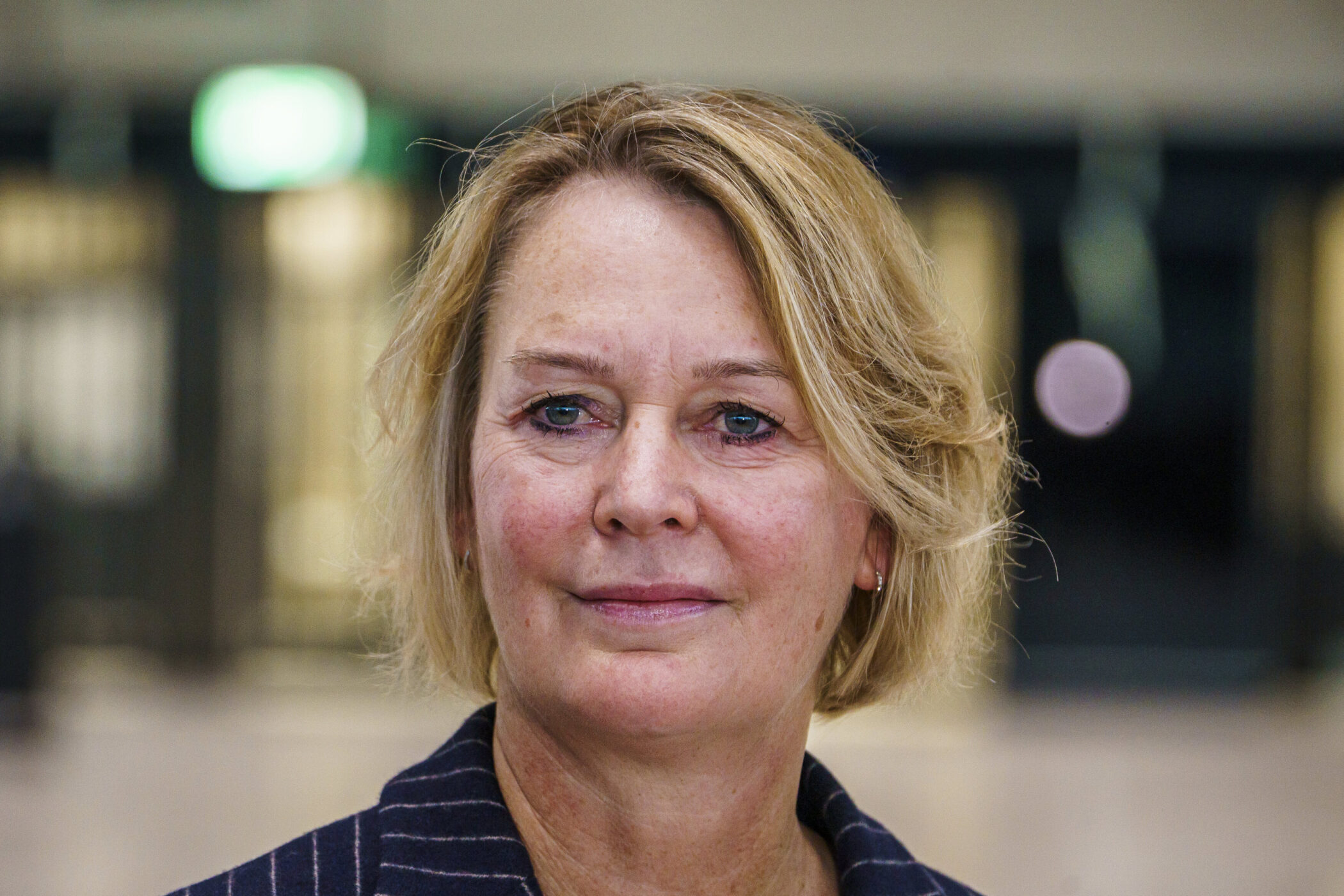 Eine Person mit blonden Haaren in einem Innenraum.