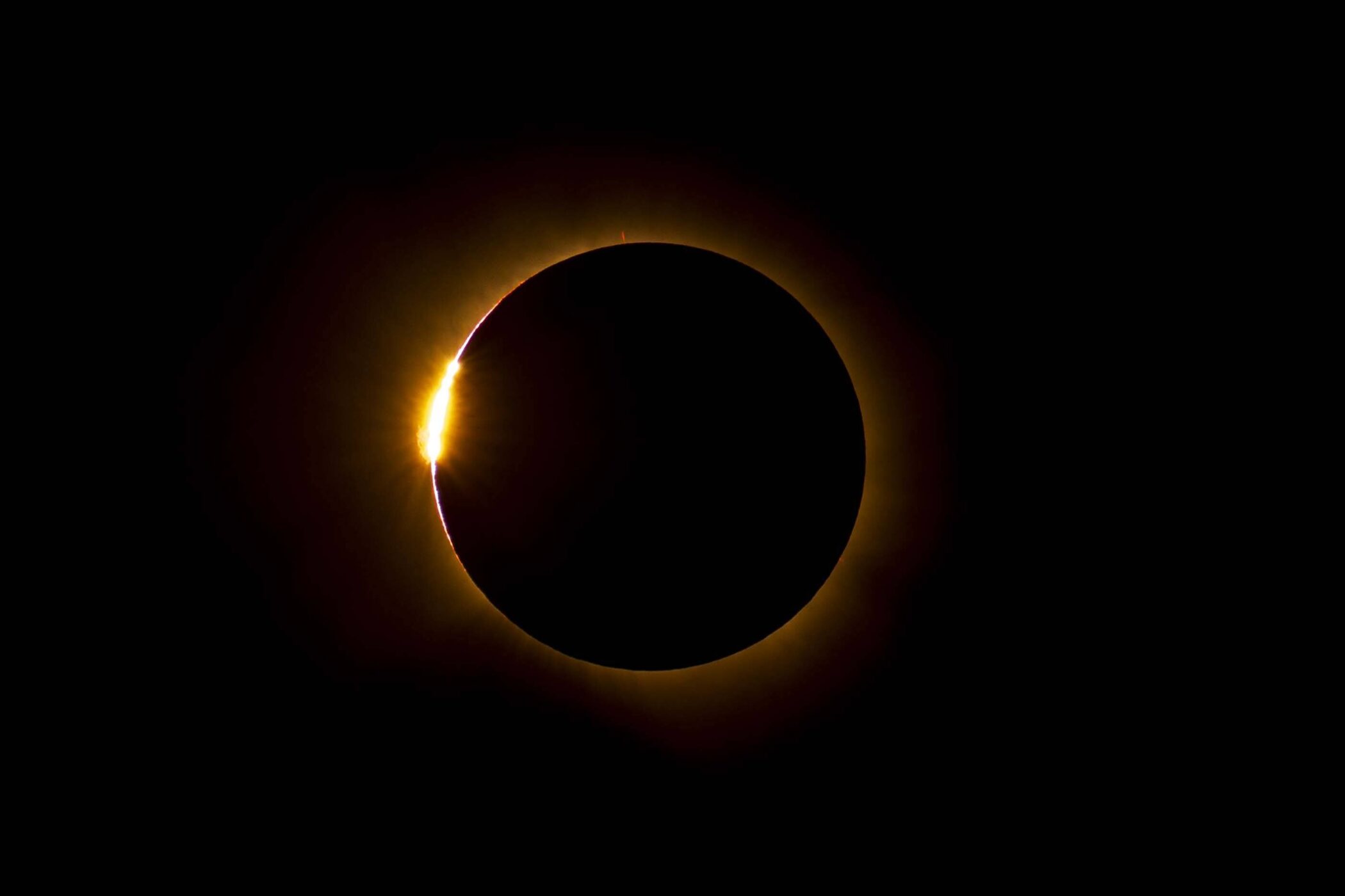 Leuchtender Ring um dunkle Scheibe vor schwarzem Hintergrund.