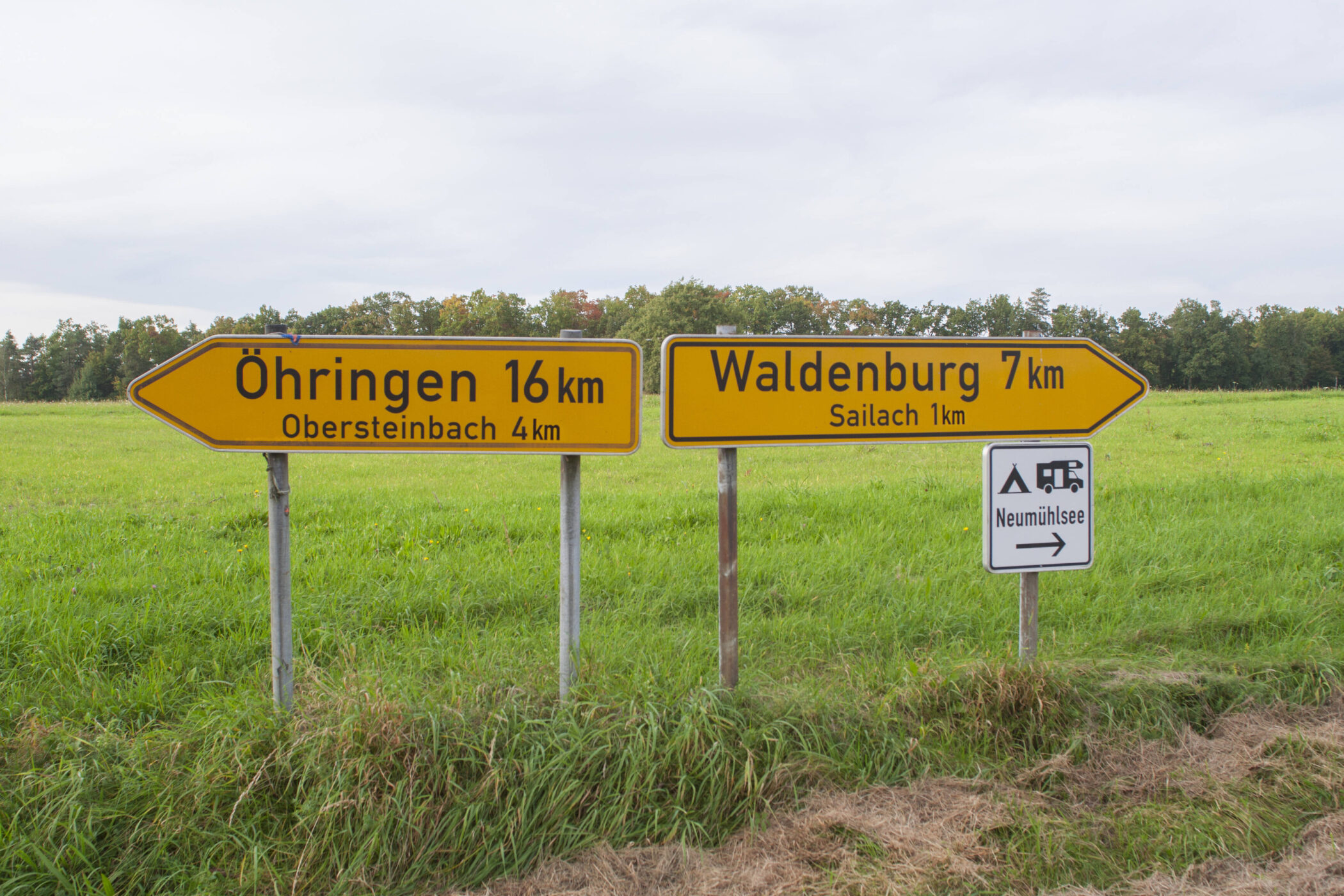 Eingabelandstraße mit Wegweisern nach Öhringen und Waldenburg. Camping-Schild rechts.