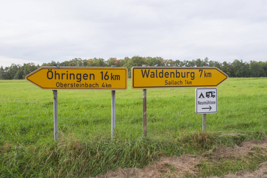 Eingabelandstraße mit Wegweisern nach Öhringen und Waldenburg. Camping-Schild rechts.