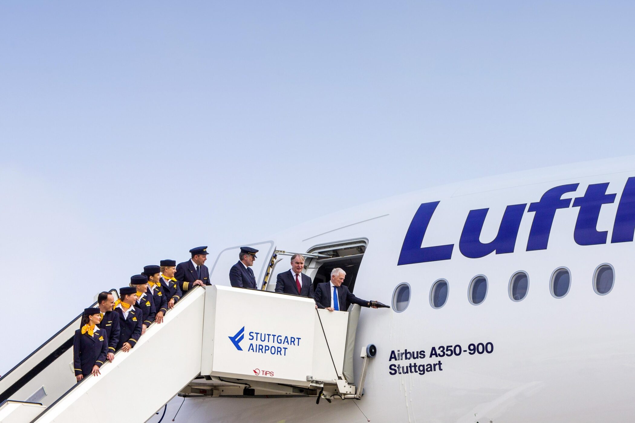 Menschengruppe auf Flugzeugtreppe mit „Stuttgart Airport“-Schriftzug am Airbus A350.