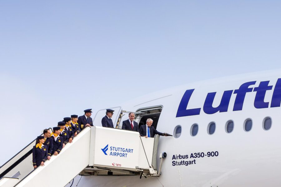 Menschengruppe auf Flugzeugtreppe mit „Stuttgart Airport“-Schriftzug am Airbus A350.