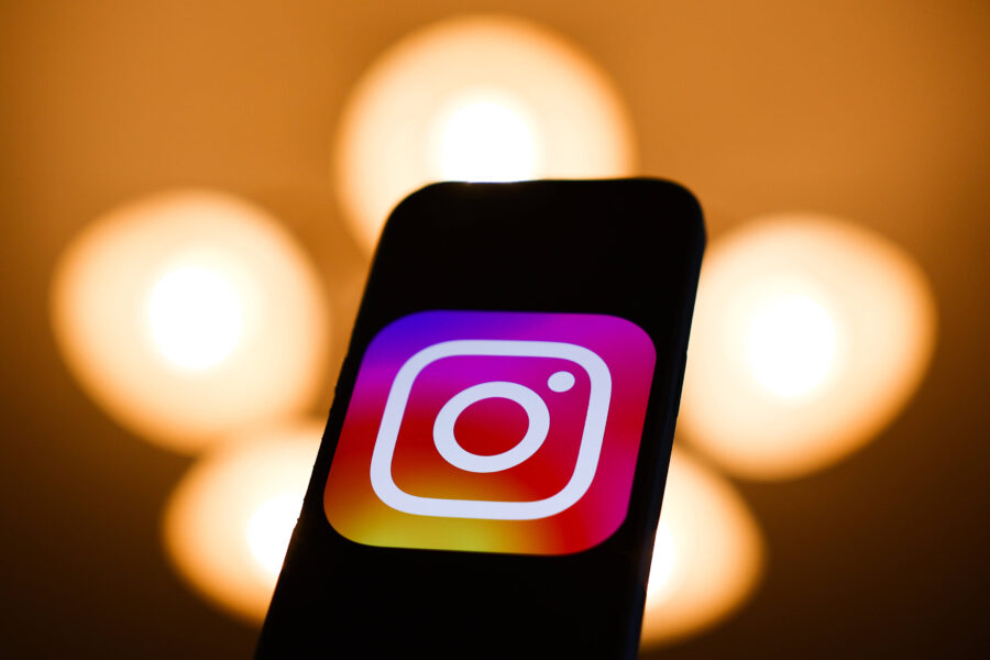 Smartphone mit Instagram-Logo vor unscharfen, runden Lichtern im Hintergrund.