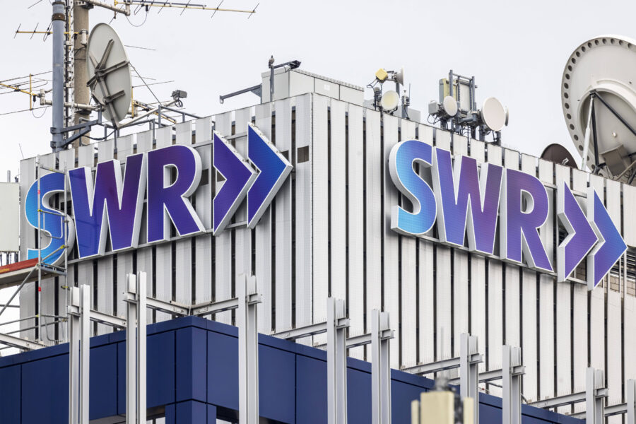 Gebäudedach mit großen SWR-Logos und zahlreichen Satellitenschüsseln.