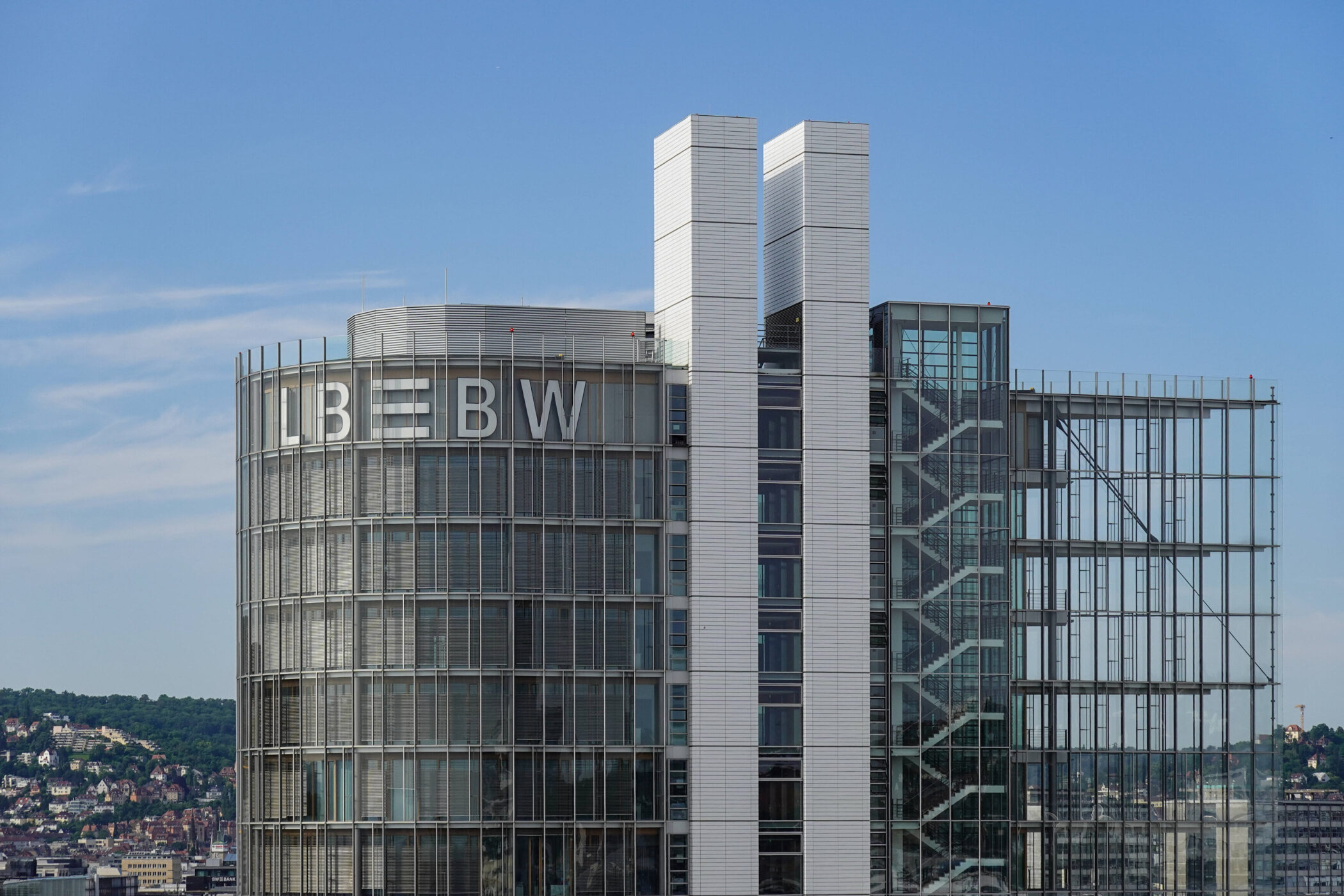 Rundes Gebäude mit „LBBW“-Schriftzug, klare Glasstrukturen, blauer Himmel.