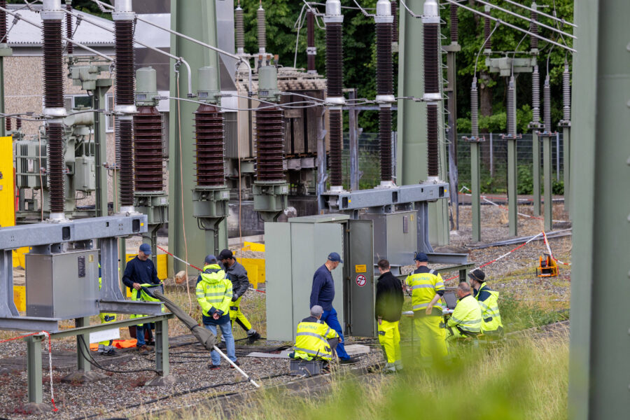 Mehrere Menschen in Schutzkleidung bei Arbeiten an Transformatorstation.
