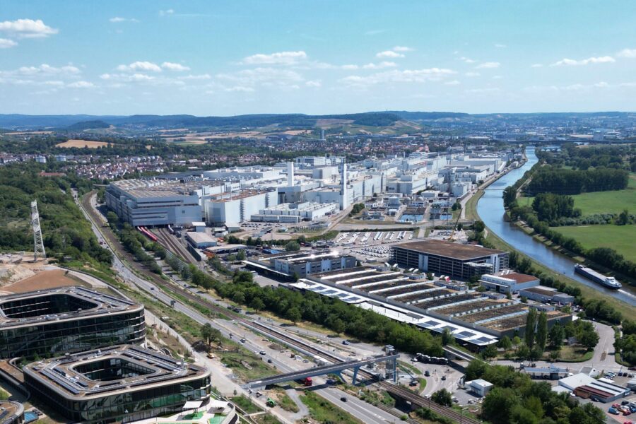 Industrieanlage und Fluss, umliegende Landschaft mit Feldern und Siedlungen.