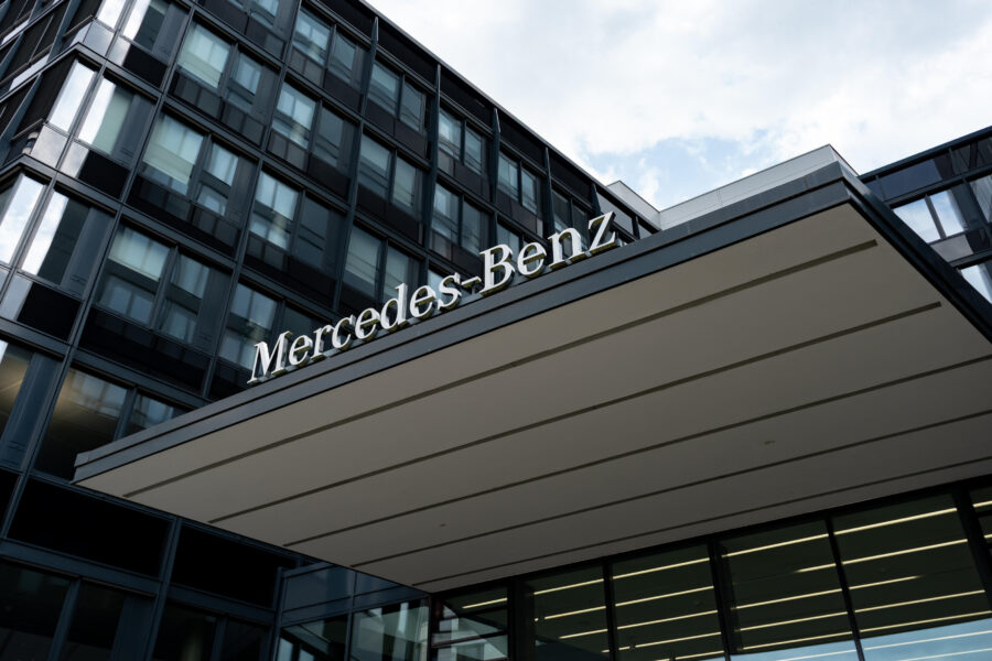 Gebäude mit Glasfassade, Schriftzug "Mercedes-Benz" auf Vordach.