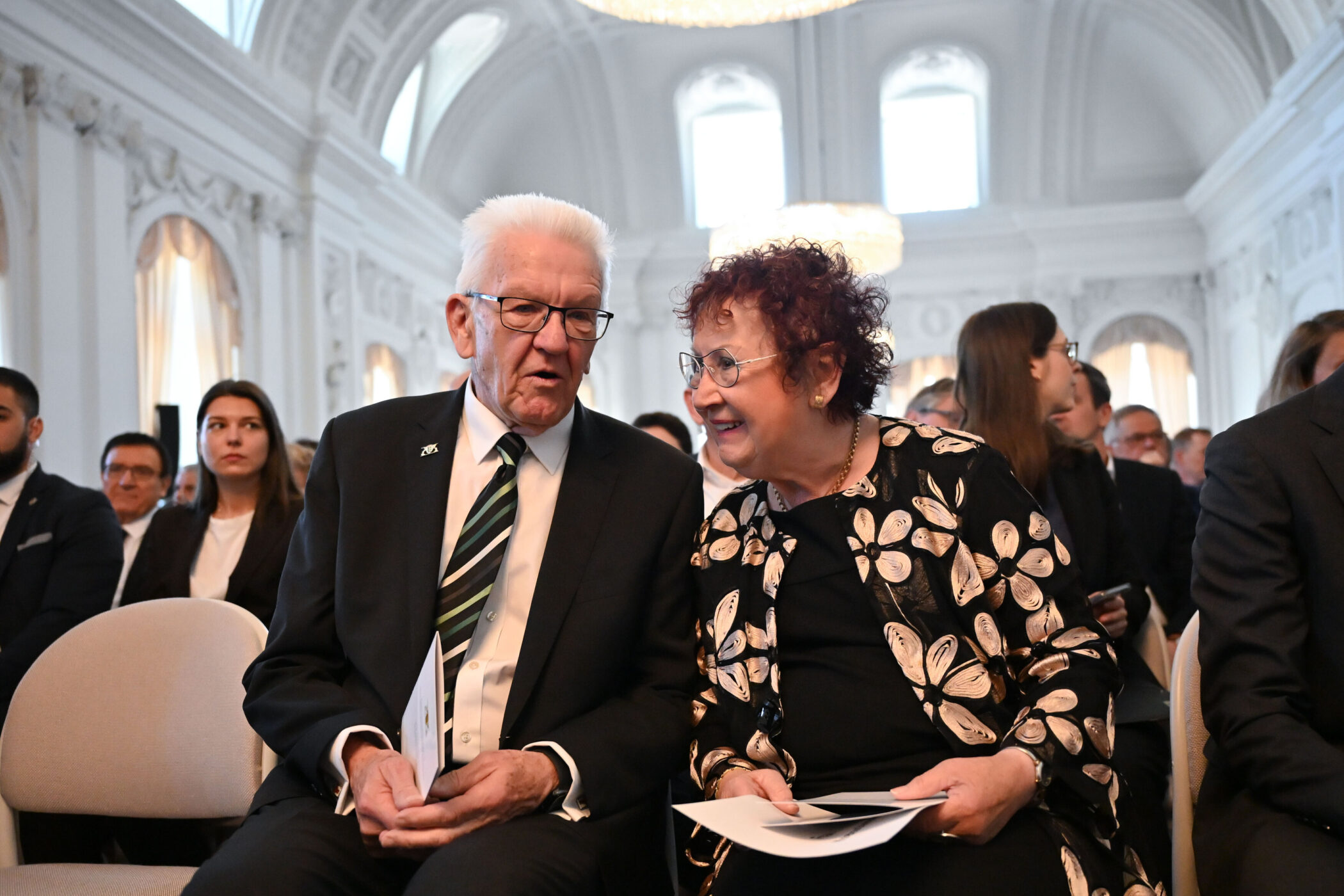 Ein Mann und eine Frau sitzen nebeneinander und unterhalten sich.