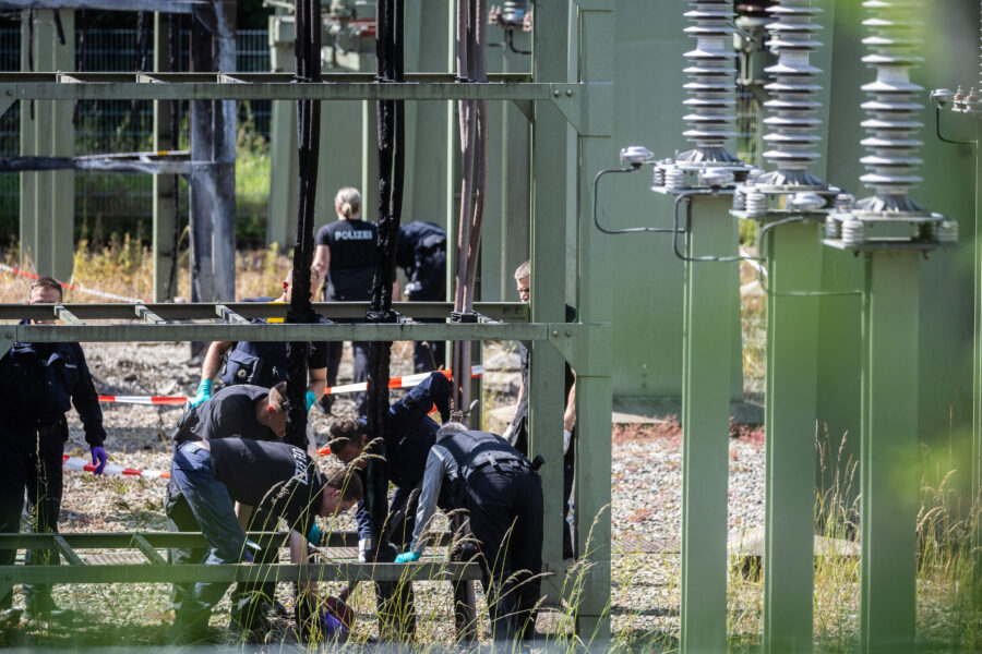 Mehrere Personen in Uniformen bei Ermittlungen in einer technischen Anlage.