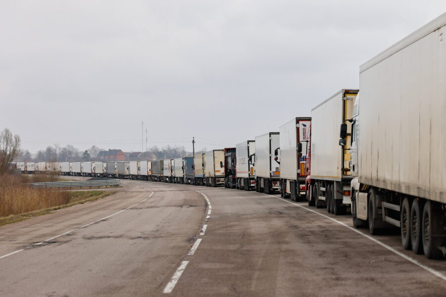 Lange Reihe von Lastwagen auf einer Straße unter grauem Himmel.
