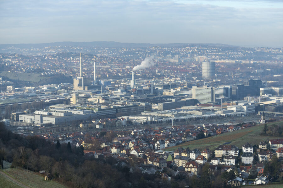 Industrieanlagen und Wohngebäude in einer weitläufigen Stadtlandschaft.