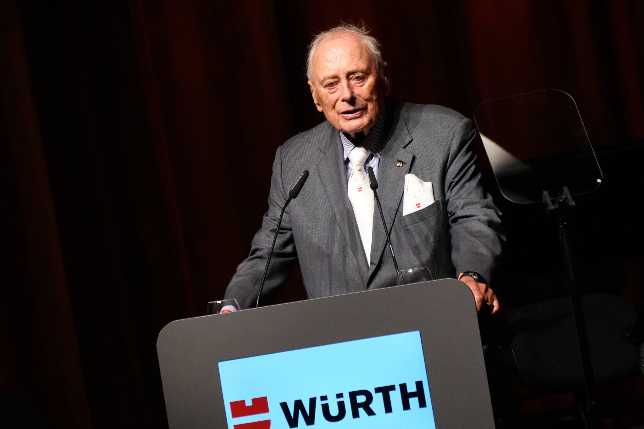 Ein Mann am Rednerpult mit der Aufschrift "WÜRTH".