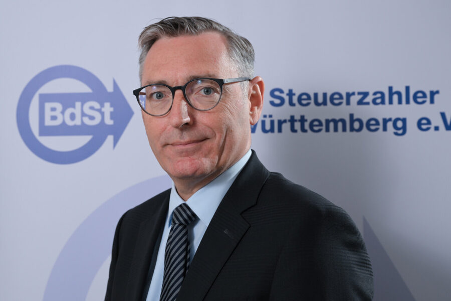Mann mit Brille im Anzug, Hintergrund: Logo und Text BdSt Steuerzahler.