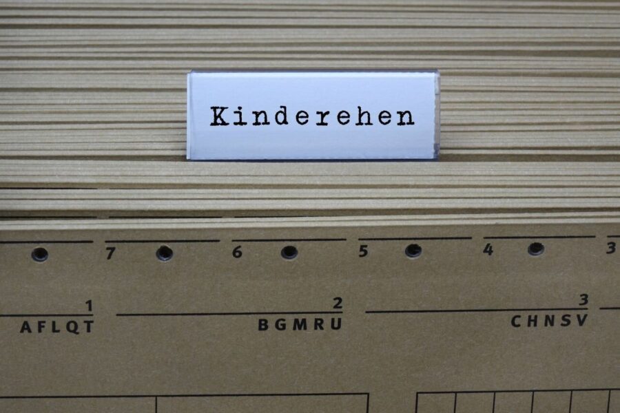 Karteikarte mit der Aufschrift "Kinderehen" vor Aktenordnern.