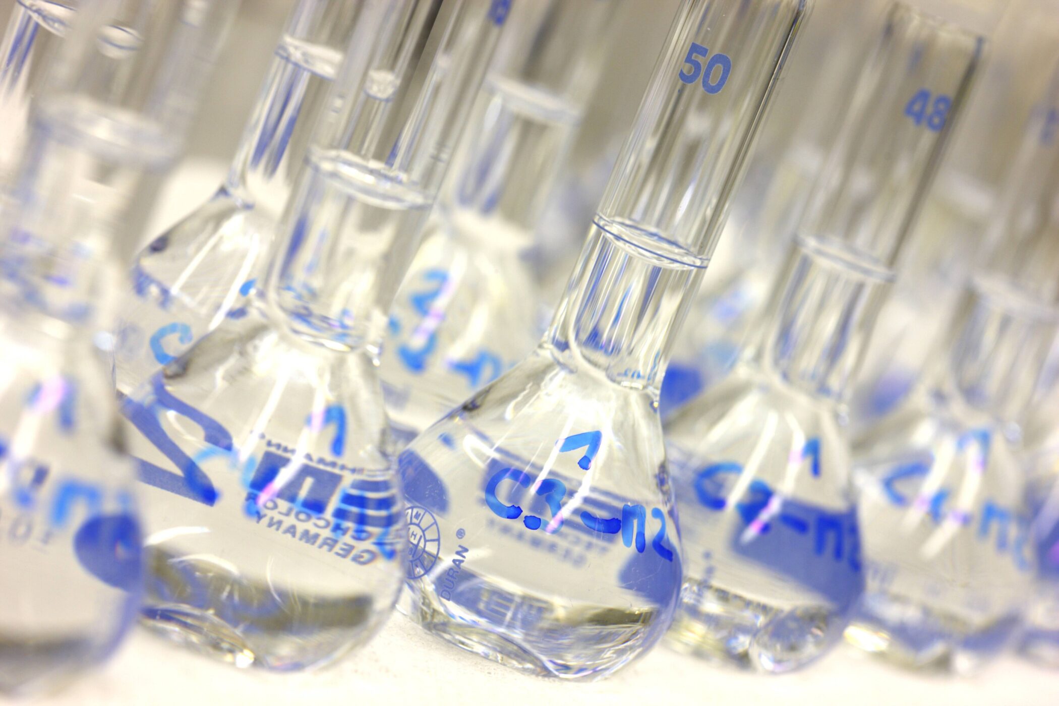Mehrere Glasflaschen mit blauen Messmarkierungen.