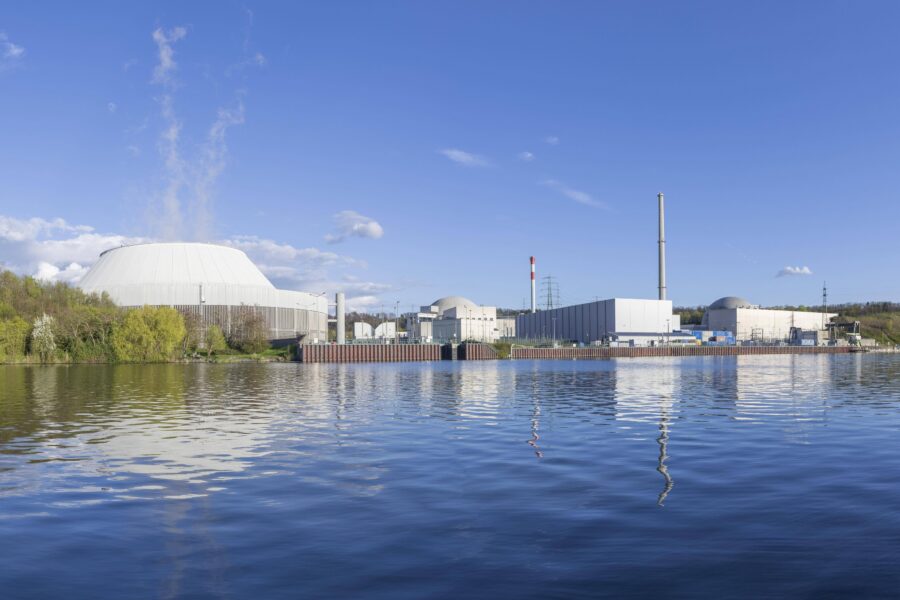 Industrieanlagen am Flussufer, blauer Himmel mit Wolken.
