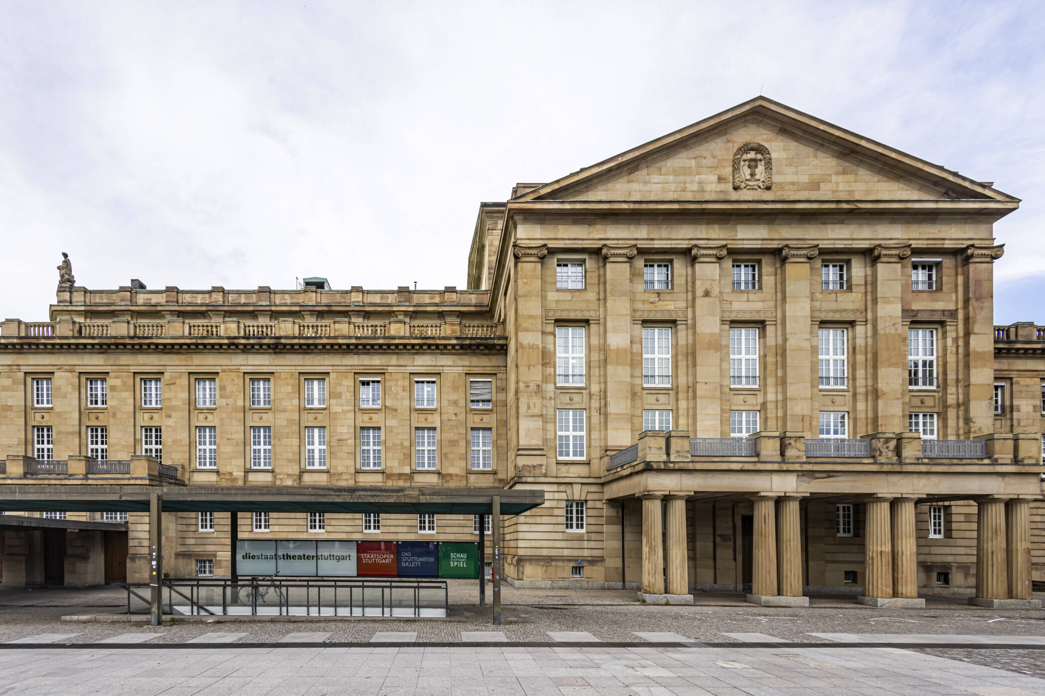 Großes, klassisches Gebäude mit Säulen, viele Fenster, Statue auf dem Dach.
