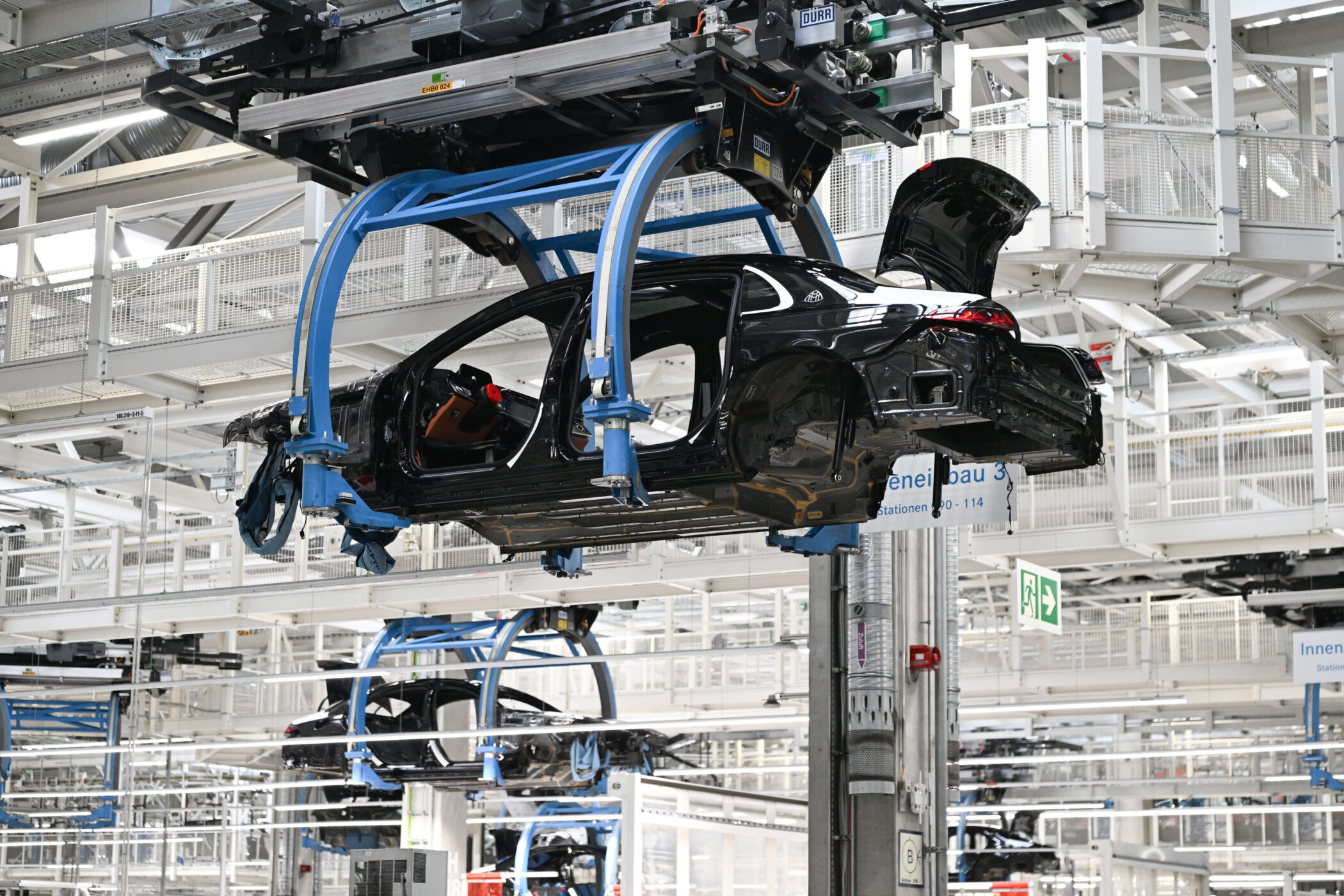 Autos in einer Fabrik, hängend an Montagesystemen.