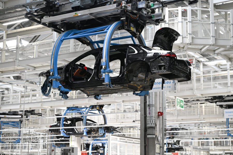 Autos in einer Fabrik, hängend an Montagesystemen.
