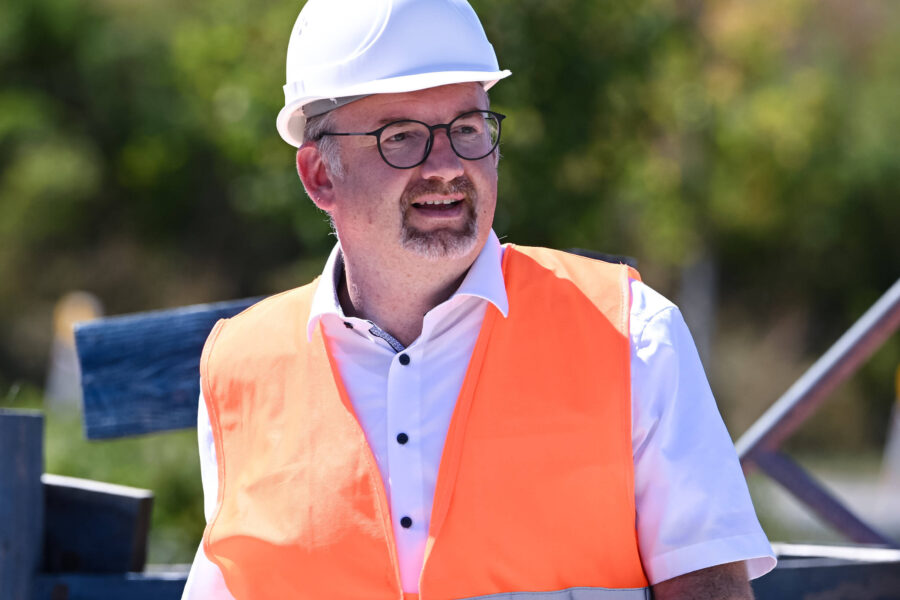 Mann mit Helm und Warnweste im Freien.