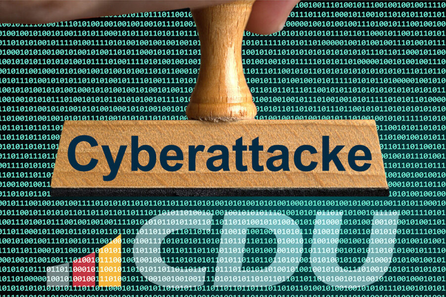 Stempel mit "Cyberattacke" vor Binärcode-Hintergrund.
